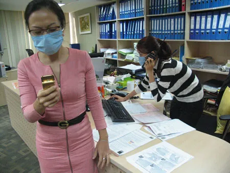 Gần như tòan bộ nhân viên làm việc trong Tòa nhà Petrol Việt Nam (số 1-5 Lê Duẩn Q.1 TPHCM) đã quen với việc đeo khẩu trang trong khi làm việc. Ảnh: Trần Thanh