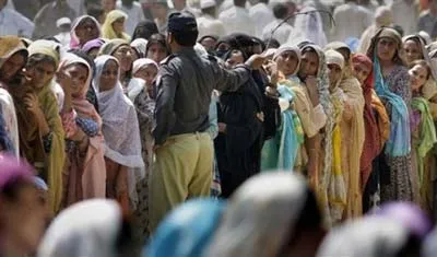 Những người phụ nữ Pakistan xếp hàng nhận trợ cấp bột mì từ chính quyền cho tháng Ramadan