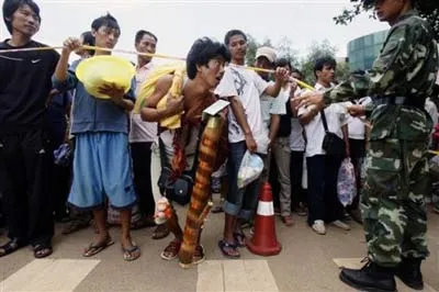 Một người tị nạn Myanmar cúi đầu vượt qua dây an toàn của cảnh sát để vào Nansan Vân Nam
