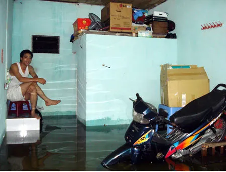 Một người dân ở phường Hòa Thuận, quận Hải Châu (Đà Nẵng) phải thức trắng đêm vì mưa lớn ngập nhà. Ảnh: Nguyễn Hùng