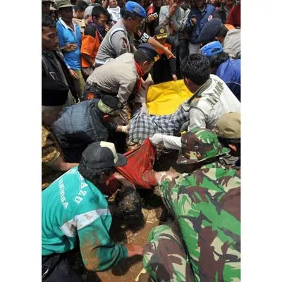 Lực lượng cứu hộ và người dân đưa thi thể nạn nhân của trận lở đất ở làng Pamoyanan ra khỏi đống bùn đất.