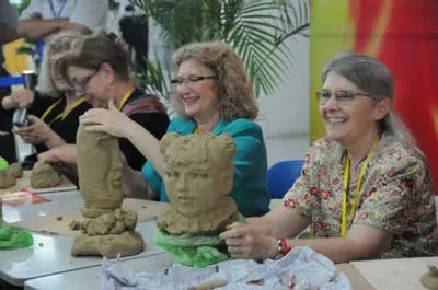 Khách tam quan nhí đang tự nặn đồ gốm sứ (ảnh trên) và khách quốc tế cũng thích thú khi được tham gia thực hiện các sản phẩm gốm sứ tại triển lãm.