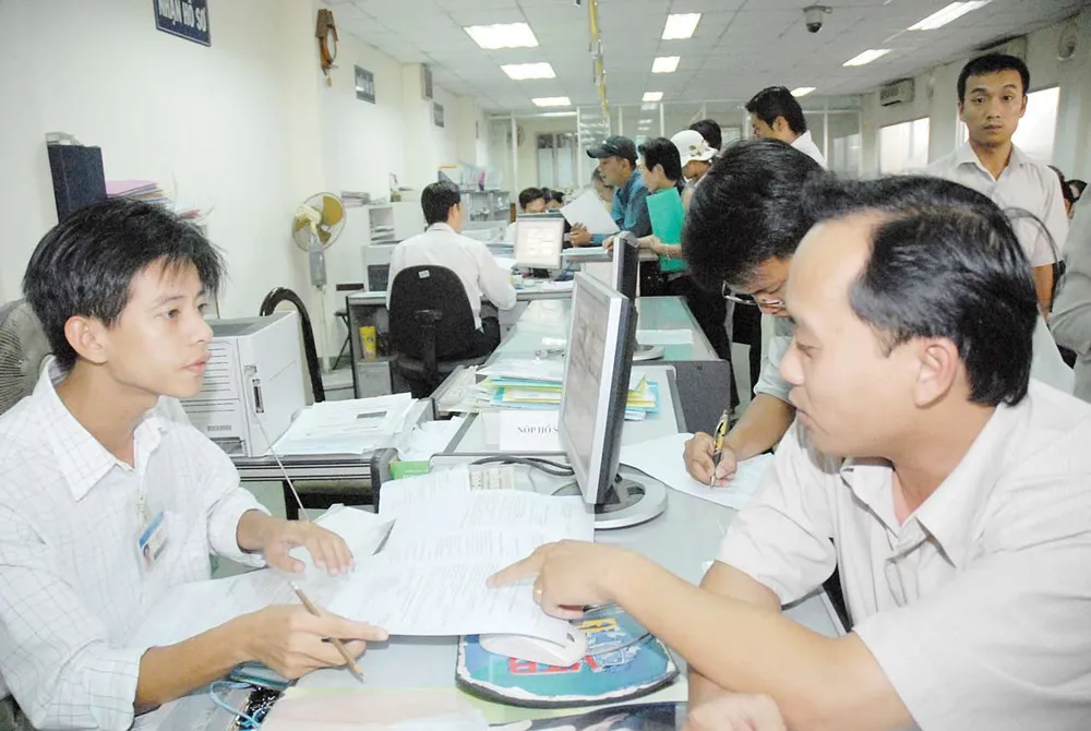 Nhân viên Sở KH - ĐT hướng dẫn doanh nghiệp làm hồ sơ. Ảnh: CAO THĂNG