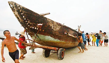 Ngư dân phường Thọ Quang, quận Sơn Trà, TP Đà Nẵng khẩn trương đưa tàu thuyền lên bờ tránh bão. Ảnh chụp chiều 27-9. Ảnh: Nguyên Khôi
