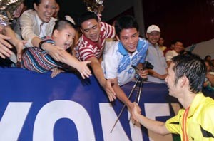 Nguyen Tien Minh (R) shares happiness with fans at Phan Dinh Phung Stadium after becoming the men’s singles champion (Photo: SGGP)