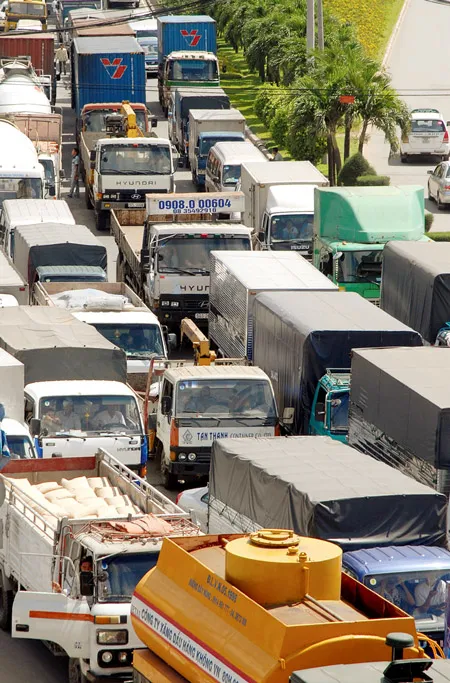 Xe tải kẹt nối đuôi trên đường Nguyễn Hữu Cảnh - một minh chứng thiệt hại cho sản xuất, nền kinh tế. Ảnh: ĐỨC TRÍ