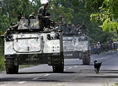 Philippine Army armoured personnel carriers and trucks move down a highway of the town of Datu Piang in Maguindanao on military actions against separatist rebels in May 2009