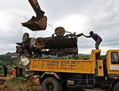 A backhoe lifts a mangled vehicle unearthed from a shallow grave as investigators try to find more bodies, victims of a massacre in Ampatuan town, Maguindanao province. (AFP photo)