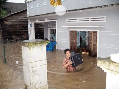 Người dân buôn A Ma Dương (Ayun Pa) chuyển tài sản ra khỏi những căn nhà ngập nước.