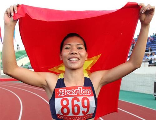 Vu Thi Huong celebrates her win in the 100 meter race at the National Sports Complex, Vientiane, on Dec. 13 (Photo: Tuoi Tre)