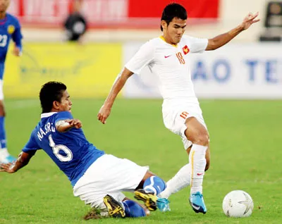 Thanh Bình (áo trắng) bất lực trước pha cản phá quyết liệt của hậu vệ Malaysia. Ảnh: Quang Nhựt.