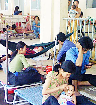 Do quá tải, người thân phải kê ghế bố, chăm sóc cho bệnh nhi ngoài hành lang tại Khoa tiêu hóa BV Nhi đồng 2 TPHCM. Ảnh: TG.LÂM