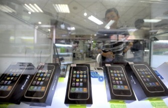 A salesman sits behind a display showing real Apple iPhones in a counter in Beijing in this October 28, 2009 file photo. (AFP photo)