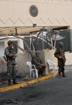 Yemeni guards stand outside the US embassy in Sanaa, one day after an attack on the embassy killed 19 people in 2008.