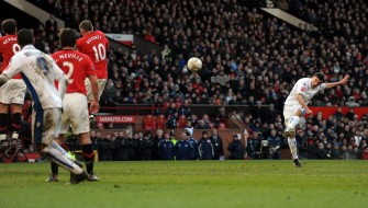 Leeds United's Robert Snodgrass (R) takes a free kick which hits the crossbar during their English FA Cup football match against Manchester United at Old Trafford in Manchester on January 3, 2010. AFP PHOTO