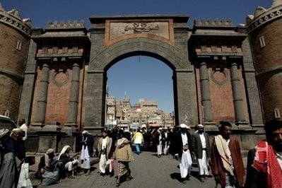 (File) Yemenis walking under the iconic Yemen Gate leading to the old city of Sanaa (AFP photo)