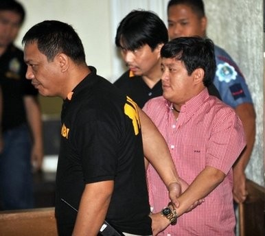 Police officers escort Andal Ampatuan Jnr (right), the prime suspect in the country's worst political massacre, inside a court in Manila on January 5. (AFP photo)