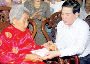 President Nguyen Minh Triet (R) pays a visit to Vietnamese Hero Mother Pham Thi Thung in Phuoc Long Town on Jan. 5