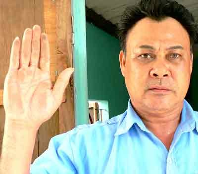 Resident Dinh Van Tien of central Khanh Hoa Province holds up his hand to show what he says is a layer of toxic copper slag dust which continually accumulates in his home. Locals are worried that the substance used by the HVS company is harming their health (Photo: SGGP)