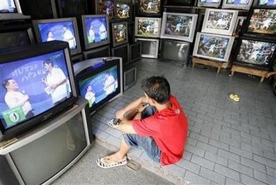An employee watches a program inside an appliance store selling second-hand television in Manila July 4, 2008. (AFP Photo)
