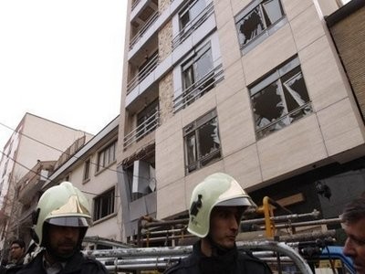 Iranian firemen stand outside the building where a remote-controlled bomb explosion killed an Iranian university lecturer in Tehran