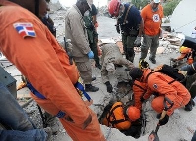 Members of a Dominican rescue team attempt to save a victim trapped amid the rubble of a destroyed building in Port-au-Prince. (AFP Photo)