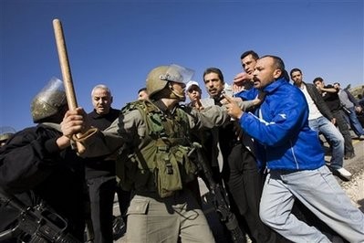 Israeli border police, left, and Palestinian demonstrators scuffle during a protest over a disputed water well in the West Bank village of Deir Netham near Ramallah, Friday, Jan. 15, 2010. (Photo: AFP)