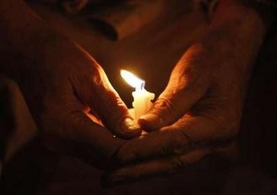 A man holds a candle during a vigil for United Nations workers and other victims of Tuesday's Haiti earthquake, at Dag Hammarskjold Park near the United Nations in New York January 15, 2010.