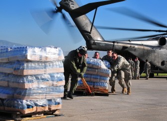 Army soldiers help the crew of a U.S. Navy MH-53E Sea Dragon helicopter from the aircraft carrier USS Carl Vinson (CVN 70) unload food and supplies at the airport in Port-au-Prince, Haiti, January 15, 2010. (AFP Photo)