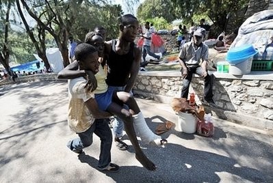 A Haitian earthquake injured victim is carried to get medical help in Port-au-Prince.