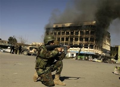 An Afghan police officer aims his weapon at the scene of attack in central Kabul, Afghanistan, Monday, Jan. 18, 2010.