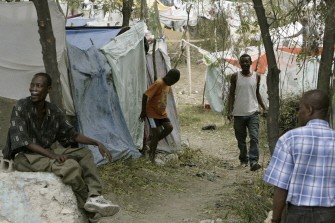 A woman inspects a banner with words seeking help scrawled by residents of a neighbourhood in Port-au-Prince on January, 19 (AFP photo)