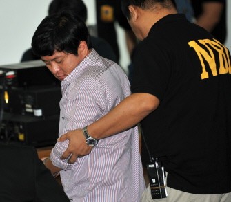 Datu Unsay Mayor, Andal Ampatuan Jr. (C)the prime suspect in the massacre of 57 people in Maguindanao province is led by a National Bureau of Investigation agent into a courtroom during the resumption of his trial at the national police headquarters compound in Manila on January 20, 2010 (AFP photo)