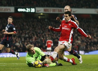 Arsenal's Cesc Fabregas (R) vies with Bolton Wanderers goalkeeper Jussi Jaaskelainen (L) during their English Premier League football match against Bolton Wanderers at the Emirates Stadium, London on January 20, 2010. AFP PHOTO