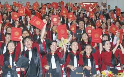 Vietnamese postgraduates celebrate during a graduation ceremony. Experts say that the country needs to improve the standards to which doctoral students are held before approving their theses. (Photo: SGGP)