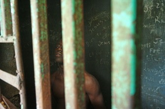 Haiti -- A man stays in an isolation's cell of a psychiatric clinic of Port-au-Prince, January 25 2010. Families who lost everything after the earthquake, decide to leave their relatives with psychaitric problems to the clinic. AFP PHOTO