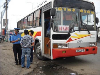 A traffic inspector slaps a fine on a bus caught picking up passengers on a road in Thu Duc District, HCMC, January 25 (Photo: SGGP)
