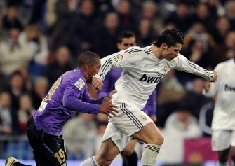 Real Madrid's Portuguese forward Cristiano Ronaldo (R) tackles Malaga's Danish defender Patrick Mtiliga (L) during a Spanish league football match at the Santiago Bernabeu Stadium, on January 24, 2010 in Madrid. AFP photo