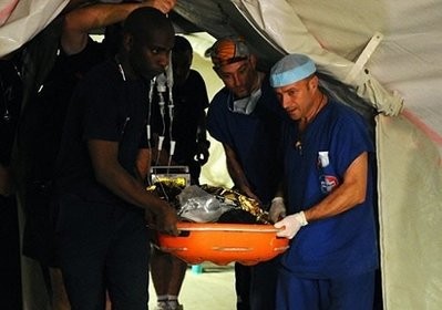 French medics carry a girl who was found alive in the rubble at the French hospital in Port-au-Prince.