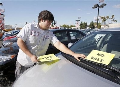 Employee Raul Quecada places a 'No Sale' sign on a used Toyota vehicle Wednesday, Jan. 27, 2010 at a Toyota dealership in Alhambra, Calif.