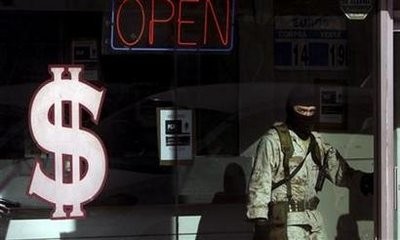 A soldier stands inside a raided pawn shop while under investigation for money laundering in Tijuana November 25, 2009