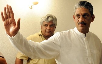 Former Sri Lankan cricketer Arjuna Ranatunga (L) looks on as former army chief and beaten presidential candidate General Sarath Fonseka (R) waves to the media in Colombo on January 28, 2010. AFP photo