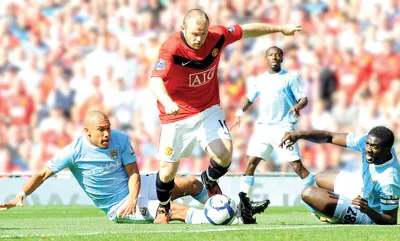 Tiền đạo Wayne Rooney (10, Man.United) thoát qua sự truy cản của cặp trung vệ Man.City để ghi bàn ở trận derby vừa qua.