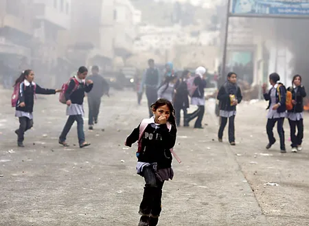 Học sinh Palestine chạy khỏi làn đạn trong cuộc giao tranh giữa người Palestine và Israel tại Hebron, Bờ Tây.