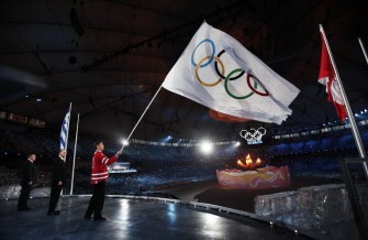 Vancouver Mayor Gregor Robertson (R) waves the Olympic flag next to International Olympic Committee (IOC) President Jacques Rogge (C) and Sochi Mayor Anatoly Pakhomov during the closing ceremony of the Vancouver 2010 Winter Olympics, February 28, 2010. AFP PHOTO