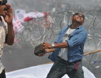 An Indonesian protestor throws a large stone at riot police during a clash outside the parliament building in Jakarta on March 2, 2010. AFP photo
