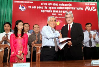 Mr. Le Hung Dung (L) shakes hands with Coach Henrique Calisto on March 4 in Hanoi during a contract-signing that will see the coach stay in Vietnam for the next three years (Photo: SGGP)