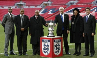 (L-R) South African footballer Aaron Mokoena, former England international John Barnes, South African President Jacob Zuma, F.A Chairman Lord Triesman, Thobeka Madiba Zuma, wife of South African President Jacob Zuma and England manager Fabio Capello pose for photographs with the FA cup at Wembley Stadium in London on March 4, 2010. AFP photo