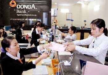 Customers at DongA Bank’s transaction office in HCMC. Experts warn the new negotiable interest policy could hurt SMEs. (Photo: SGGP)