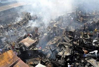 Slum dwellers are seen salvaging scraps of tin sheets and other materials from the ashes after a fire in suburban Quezon City in Manila, in 2009.